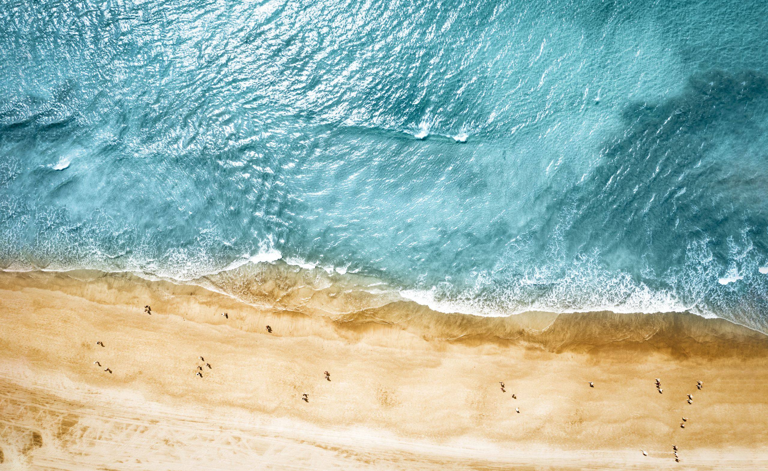 Aerial photo of summer beach and blue ocean with sky.